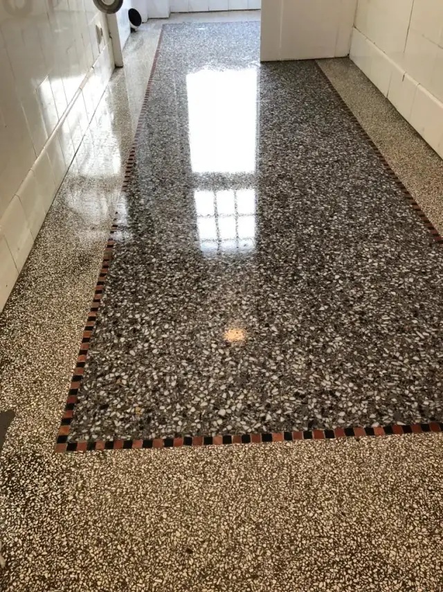 Frisch polierter Terrazzoboden in einem Flur, das Fenster spiegelt sich im Stein